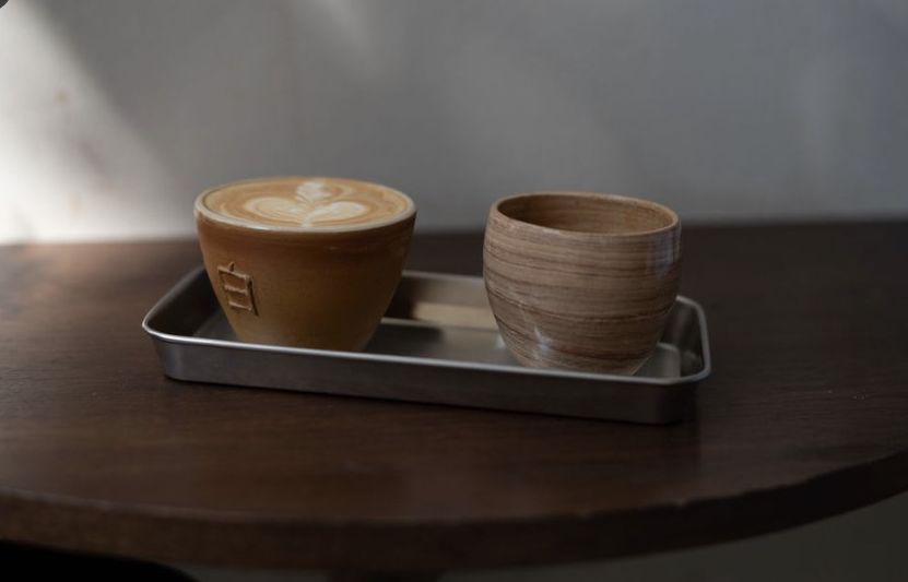 Twee kopjes koffie op een dienblad op een houten tafel