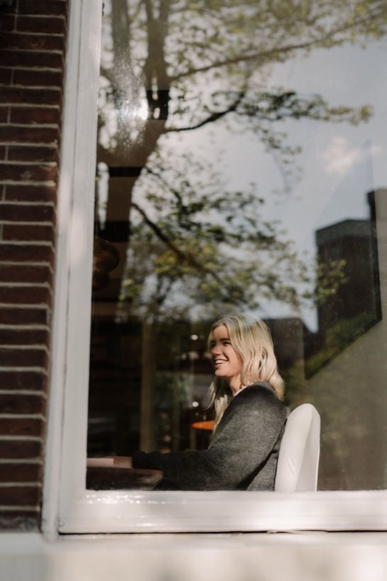 Lisa van Makelaar in Amsterdam kijkt naar buiten vanuit het kantoor