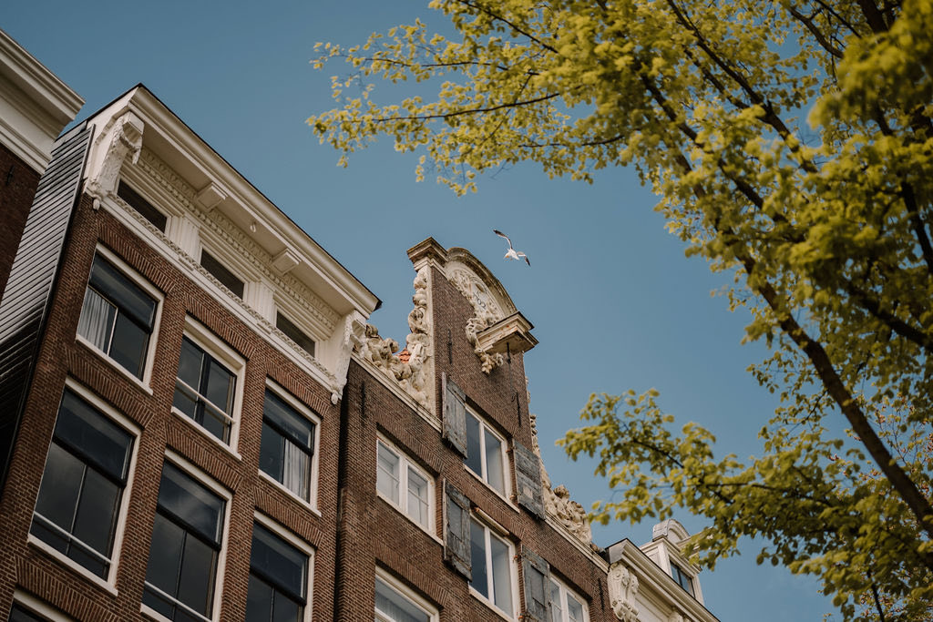 Grachtenpand in Amsterdam tegen een blauwe lucht, een woning kopen